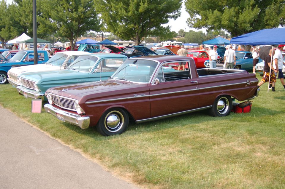 Maroon 1967 Ford Ranchero parked on grass at car show with other vehicles