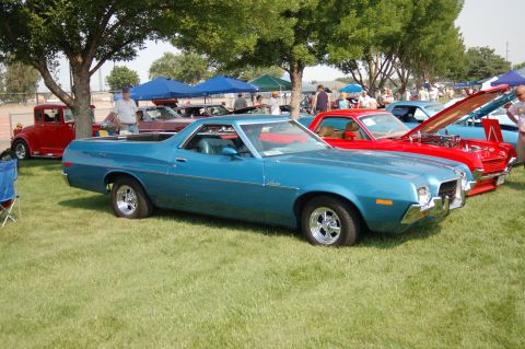 1967 Ford Ranchero - Two Ford vehicles, a blue Ranchero and a red pickup, displayed at an outdoor car show.