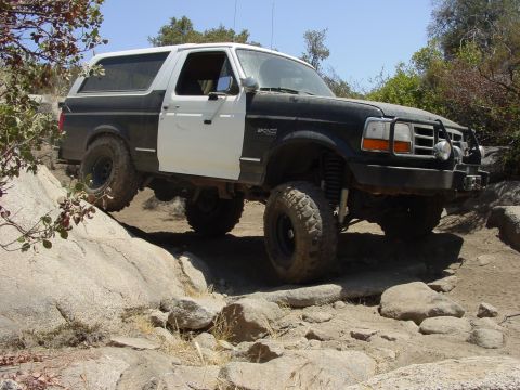1994 Ford Bronco - This lifted Ford Bronco navigates a rocky trail with its two-tone paint scheme and off-road tires.