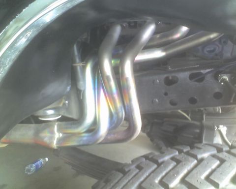 1979 Ford F-250 - Close-up view of exhaust headers and undercarriage components of a vehicle.