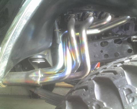 1979 Ford F-250 - Close-up view of exhaust headers and a tire, with "SUPERMOTORS" visible on a watermark.