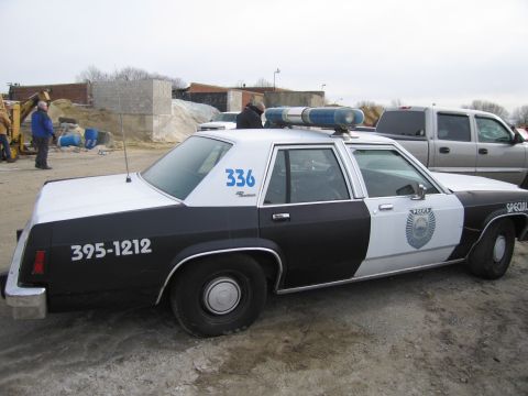 1991 Ford LTD Crown Victoria - This 1991 Ford Crown Victoria LTD police car features a distinctive black and white livery and is seen from the side.