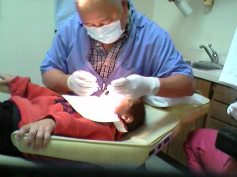 1989 Ford Bronco - A dentist performs a check-up on a young patient in a dental examination room.