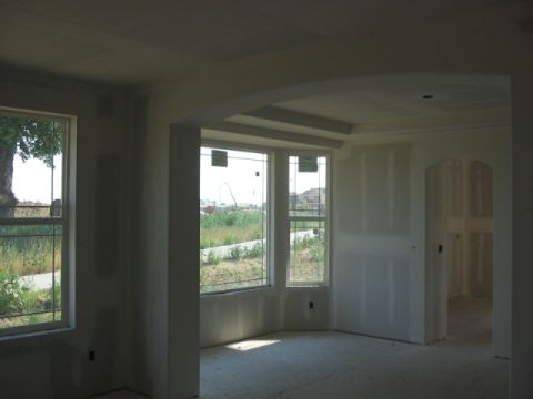 1995 Ford Bronco - Unfinished interior of a house with drywall and windows looking out onto a field.