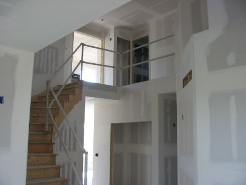 1995 Ford Bronco - Interior view of a house under construction, showing a staircase and hallway with unfinished walls.