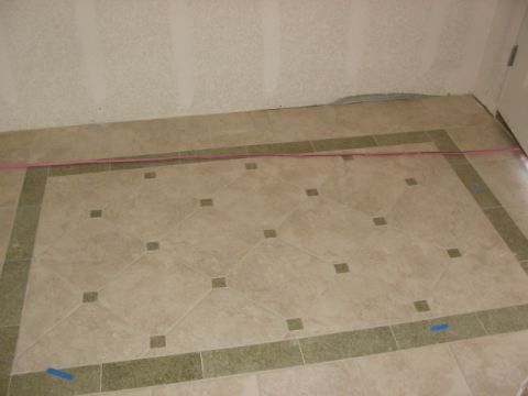 1995 Ford Bronco - A view of a tiled floor with a decorative border and a pink cord stretched across the room.