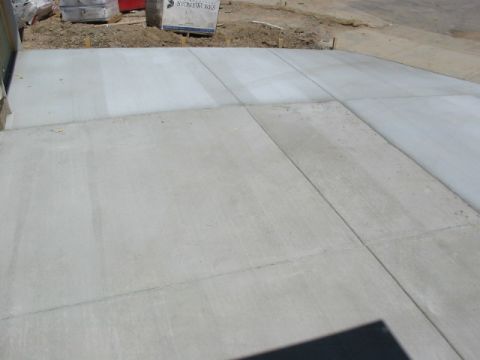 1995 Ford Bronco - A new concrete driveway has been poured, showing the distinct lines and smooth finish of the fresh cement.