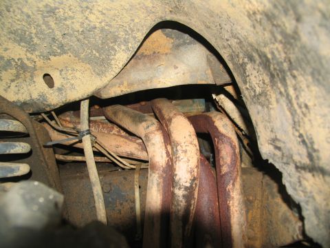 1978 Ford Bronco - Close-up view of the exhaust system and suspension components within the wheel well.