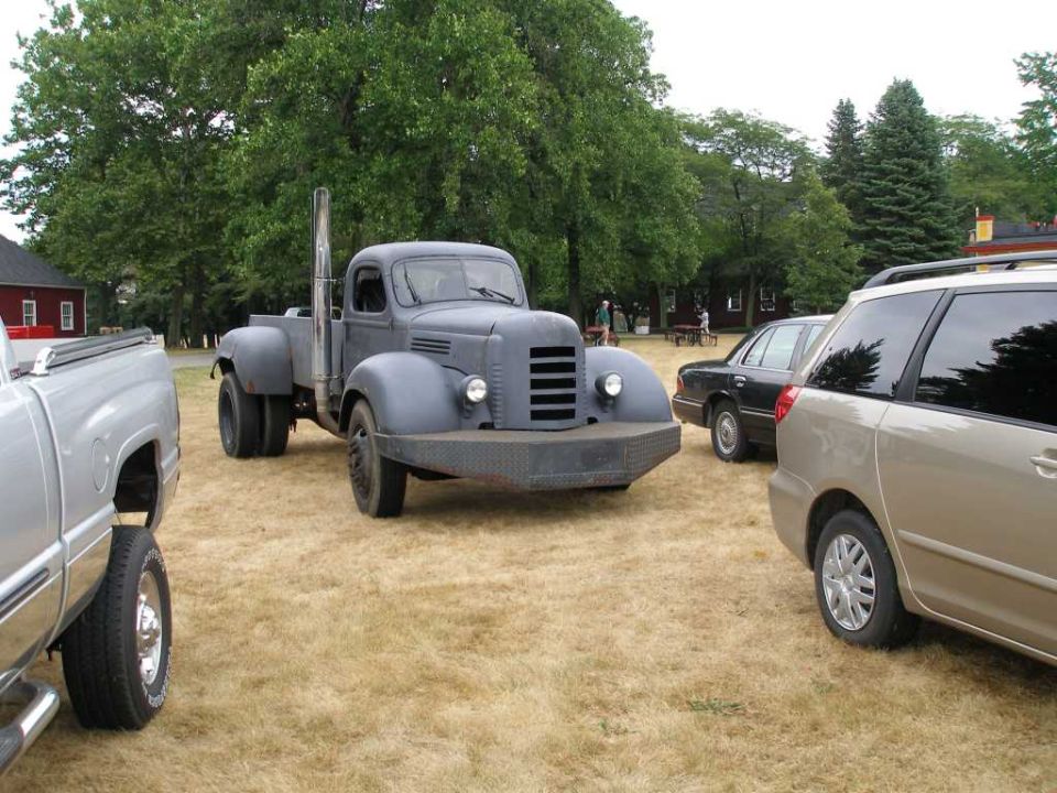 Gray vintage truck with large exhaust pipe and prominent bumper