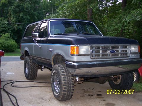 1979 Ford F-150 - This lifted 1987 Ford Bronco has a two-tone paint scheme and large off-road tires.