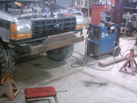 1990 Ford Ranger - A Ford truck is in a workshop with its hood up and a custom bumper being fabricated and welded onto the front.