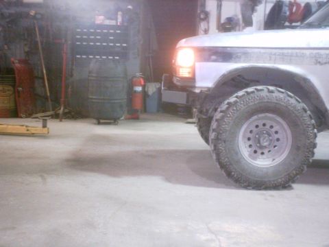 1990 Ford Ranger - Front wheel and fender of a 1990 Ford Ranger visible in a workshop setting.