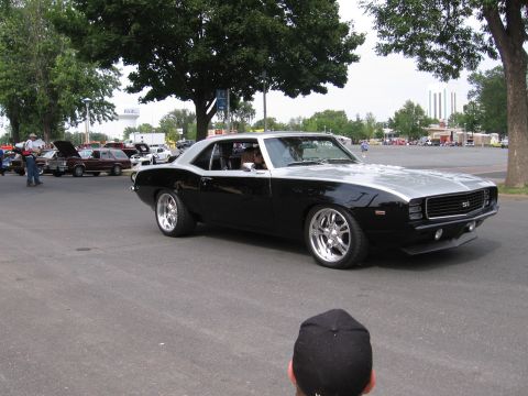 1989 Ford Mustang - A black and silver 1969 Chevrolet Camaro SS is shown from the front three-quarter view at an outdoor event.
