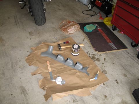 1995 Ford Bronco - A gray gauge pod and tools are laid out on brown paper on a concrete floor.