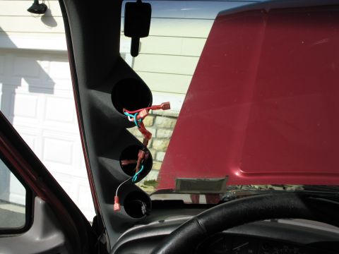 1995 Ford Bronco - Custom gauge pod installed in vehicle interior, with red hood and garage door in background.