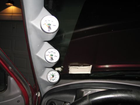 1995 Ford Bronco - Three aftermarket gauges are mounted on the A-pillar inside a vehicle.
