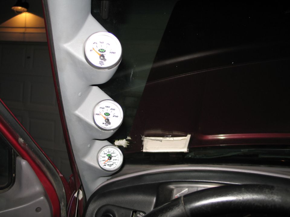 Interior shot of a car's A-pillar with three gauges installed: oil pressure, water temp, and volts