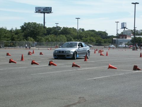 2001 Mercury Grand Marquis - A silver BMW M3 coupe is seen maneuvering through an autocross course marked by orange cones.