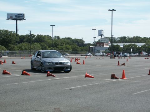 2001 Mercury Grand Marquis - BMW M3 E46 at an autocross event, maneuvering around traffic cones on a paved lot.