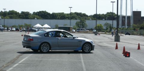 2001 Mercury Grand Marquis - A silver BMW M3 E46 navigates an autocross course with orange cones marking the path.