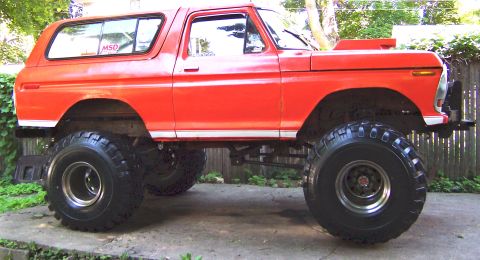 1978 Ford Bronco - This lifted 1978 Ford Bronco features oversized tires and a prominent hood scoop, suggesting off-road modifications.