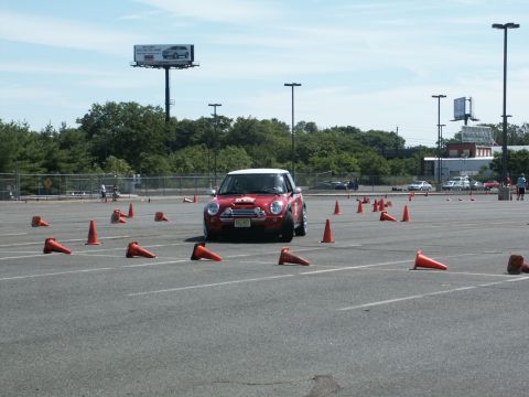 2001 Mercury Grand Marquis - A red Mini Cooper drives through an autocross course marked by orange cones.