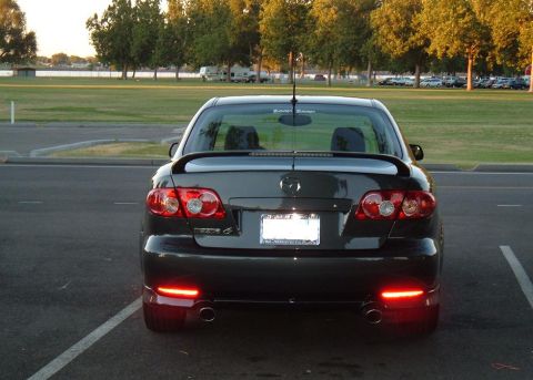 2005 Mazda 6 - The rear of a 2005 Mazda 6 sedan is shown, a spoiler and dual exhaust pipes.