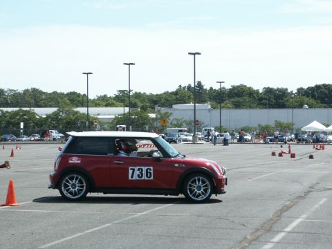 2001 Mercury Grand Marquis - Red Mini Cooper with racing number 736 participates in an event on a paved lot with cones.