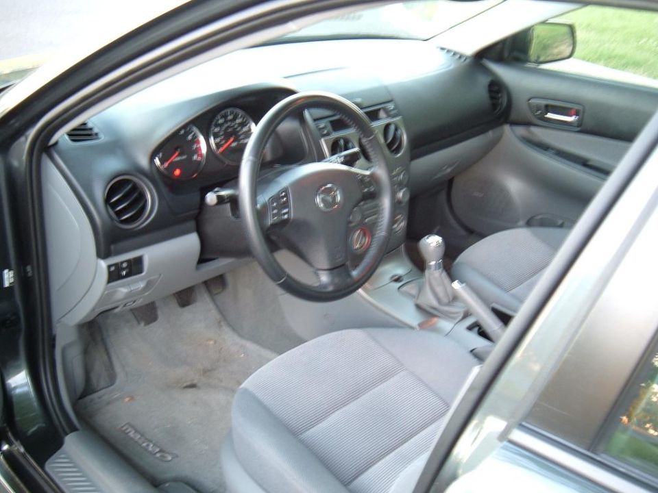 Interior shot of a 2005 Mazda 6 showing the dashboard, steering wheel, and seats