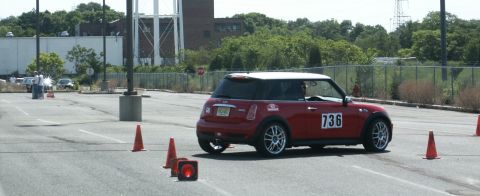 2001 Mercury Grand Marquis - Red Mini Cooper hatchback navigates an autocross course marked by orange cones.
