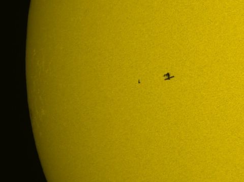 1991 Ford Probe - A satellite is visible in silhouette against the bright surface of the sun.