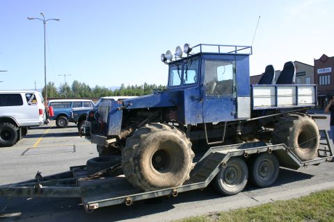 2003 Jeep TJ - Blue articulated vehicle with large tires is being transported on a trailer.