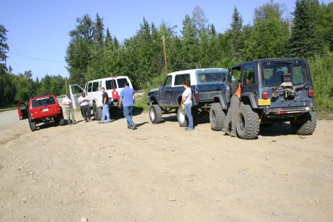 2003 Jeep TJ - Group of off-road vehicles and people gathered on a dirt road on a sunny day.