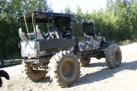 2003 Jeep TJ - This heavily modified vehicle features oversized tires and a unique open-air cabin structure.
