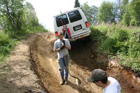 2003 Jeep TJ - Two men attempt to free a white van stuck on a challenging off-road trail.