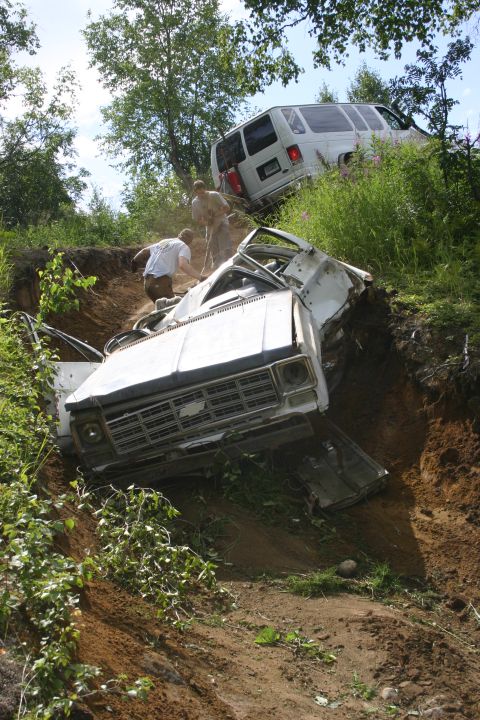 2003 Jeep TJ - Two vehicles are stuck on a steep dirt incline, with people attempting to free them.