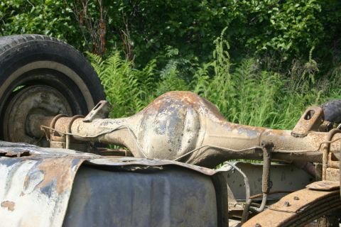 2003 Jeep TJ - Close-up of a corroded rear axle and tire, suggesting a vehicle in disrepair.