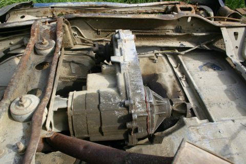 2003 Jeep TJ - The transfer case and drivetrain components are visible from underneath the vehicle, showing significant rust and wear.