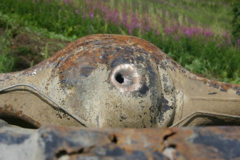 2003 Jeep TJ - A heavily rusted differential housing, likely from an older vehicle, shows significant wear and a hole in its central casing.