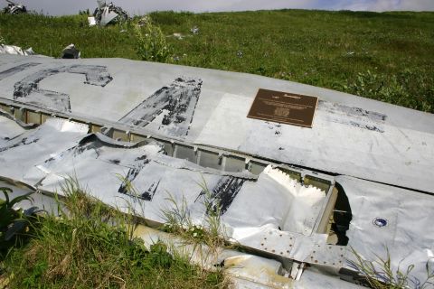 2003 Jeep TJ - Debris from an aircraft crash site, marked with a commemorative plaque, rests in a grassy field.