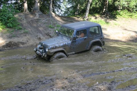 2003 Jeep TJ - Jeep TJ stuck in a muddy water crossing, tires submerged.
