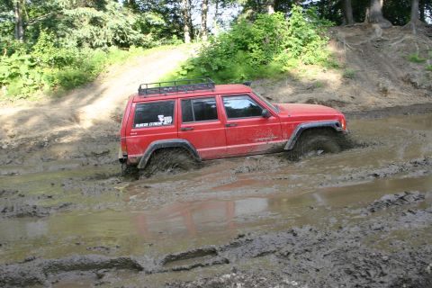 2003 Jeep TJ - This Jeep Cherokee XJ is deep in the mud, with only its roof rack visible above the mire.