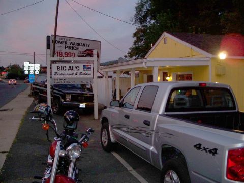 1971 Ford Ranchero - A silver pickup truck and a black SUV are parked outside a restaurant with a motorcycle in the foreground.