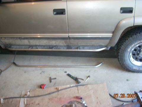 2000 Chevrolet Tahoe - A tan SUV's side is shown with its running boards and various tools scattered on the garage floor.