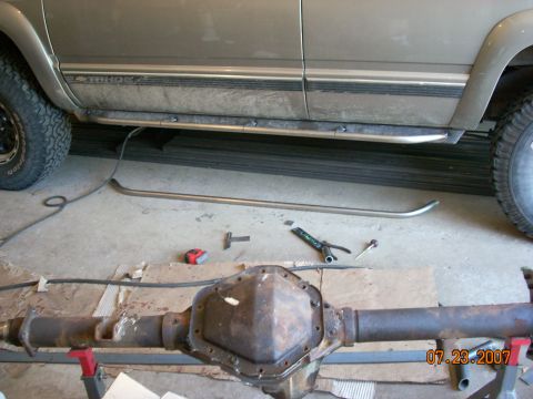 2000 Chevrolet Tahoe - A 2000 Chevrolet Tahoe is shown from the side, with a differential and tools laid out on the floor, suggesting a repair or modification.