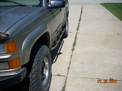 2000 Chevrolet Tahoe - This SUV, likely from the mid-1990s, is shown from the side, highlighting its running boards and tires. The registry claim of a 2000 Chevro…