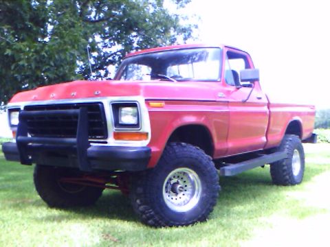 1979 Ford F-150 - This red Ford F-150 pickup truck is shown from a 3/4 front angle, a bull bar and off-road tires.