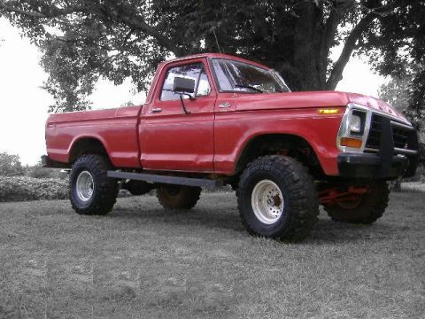 1979 Ford F-150 - This red 1979 Ford F-150 pickup truck is shown in a 3/4 front view, parked on grass under a tree.