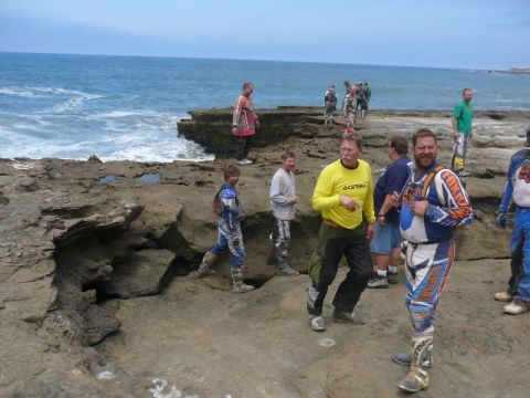 1988 Ford Bronco - A group of dirt-bike riders in muddy motocross gear, including a yellow Acerbis jersey and blue-and-orange Fox-style kit with white MX boot…
