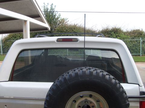 1992 Ford Bronco - Rear view of a 1992 Ford Bronco, showing the spare tire and CB antenna.